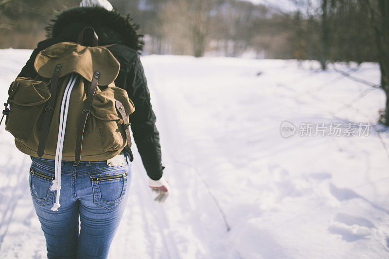 女徒步旅行者背着背包在山上行走