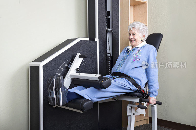 老年妇女使用腿部举重机