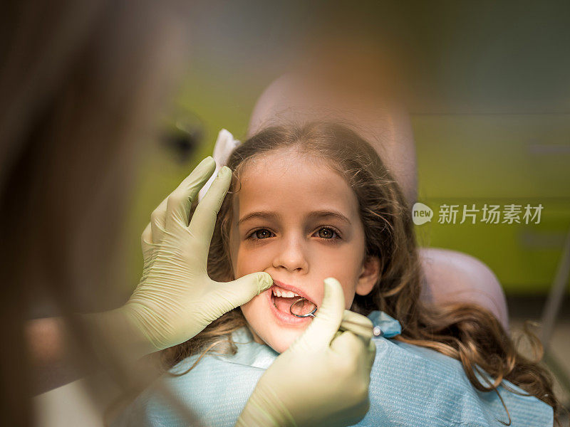 小女孩在牙医诊所检查牙齿。