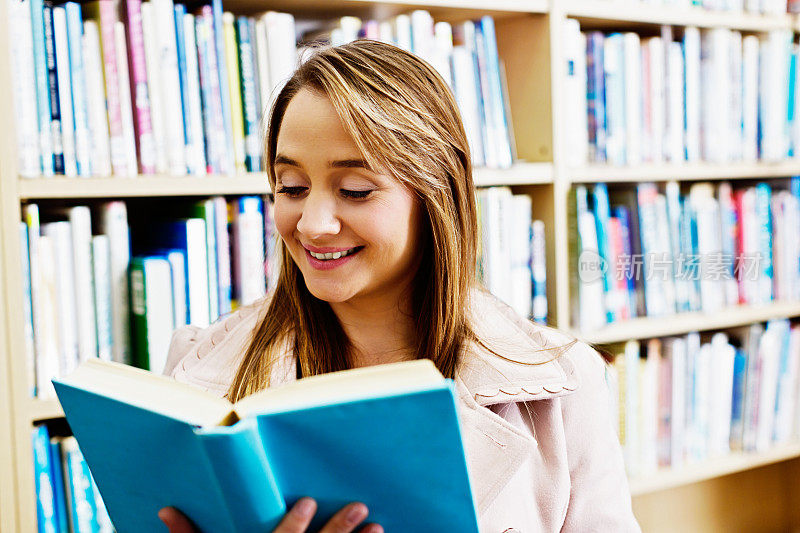 微笑的老师，图书管理员，或母亲在图书馆阅读