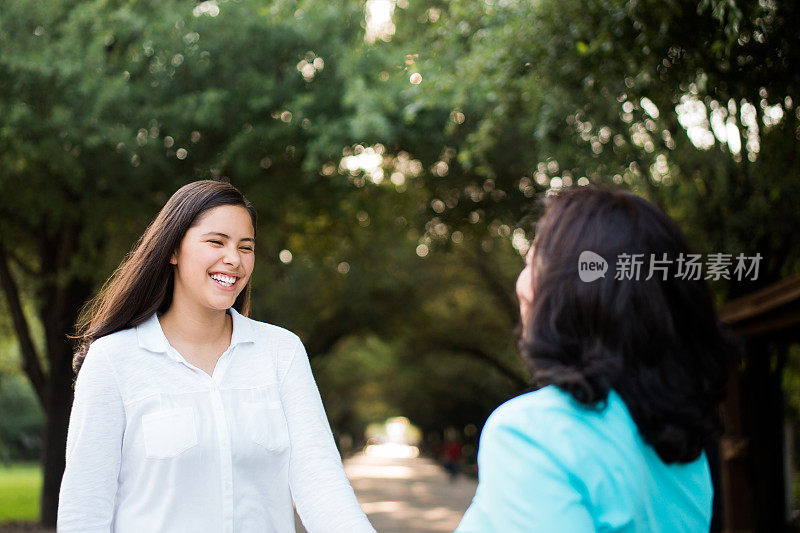 拉丁母女面对面笑着