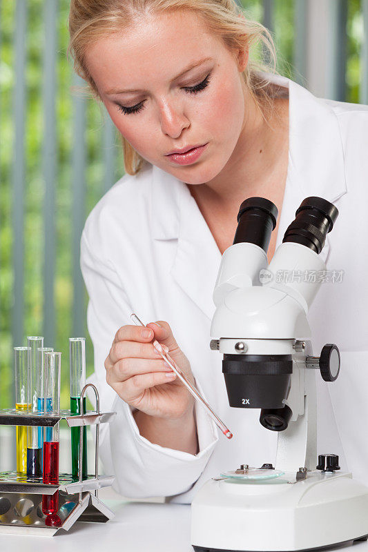 拿着显微镜的年轻女子