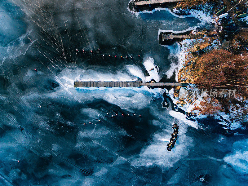 芬兰无人机拍摄的冬季冰冻湖的鸟瞰图，上面有木栈桥。