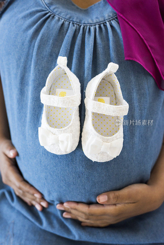 穿着婴儿鞋的孕妇