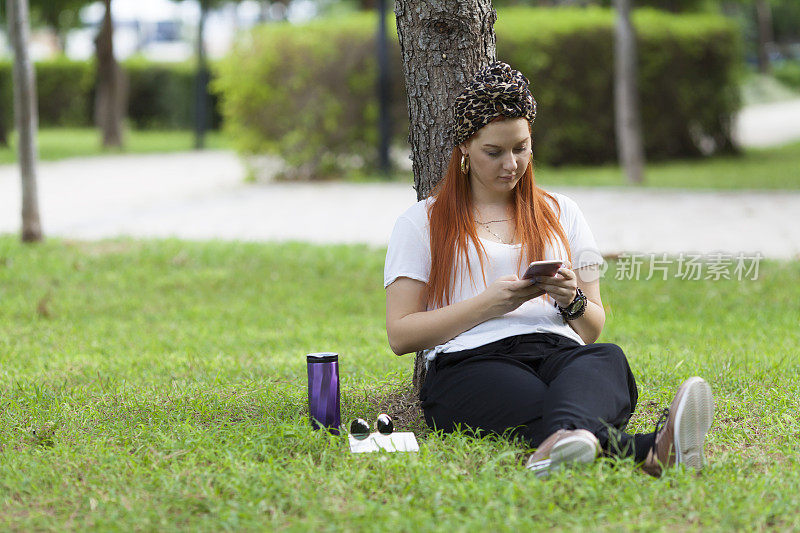 年轻女子用手机对树撒谎