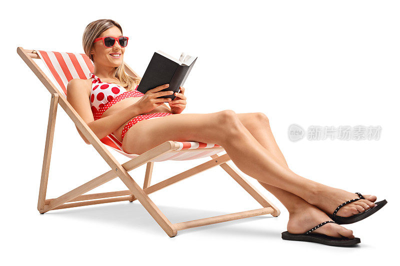 一个年轻的女人在躺椅上看书