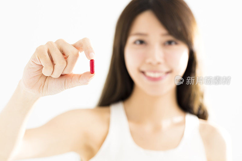 微笑的年轻女子展示在手里的药丸