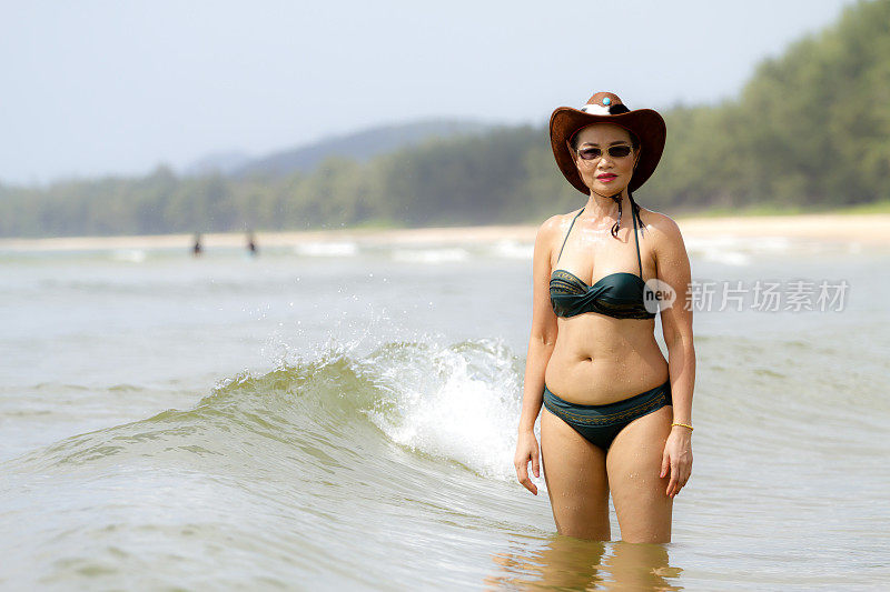 女人造型性感展示比基尼和帽子在海滩上
