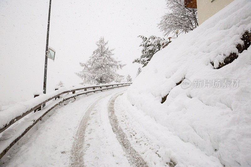 一场暴风雪中，一条被雪覆盖的道路蜿蜒穿过瑞士策马特滑雪场