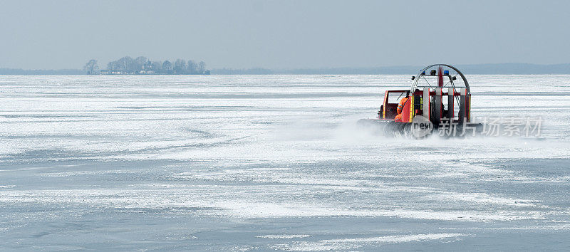 红色的汽艇在结冰的湖面上滑行