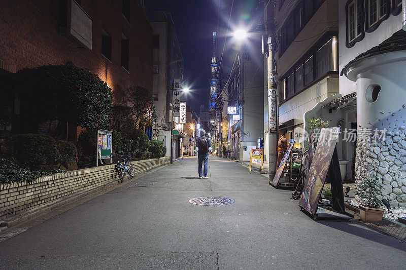 一名游客站在浅草的夜间街道上