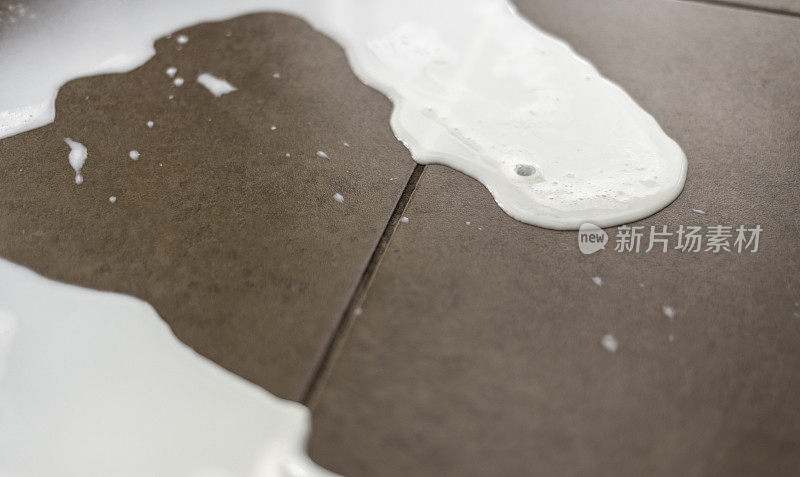 牛奶洒在瓷砖地板上