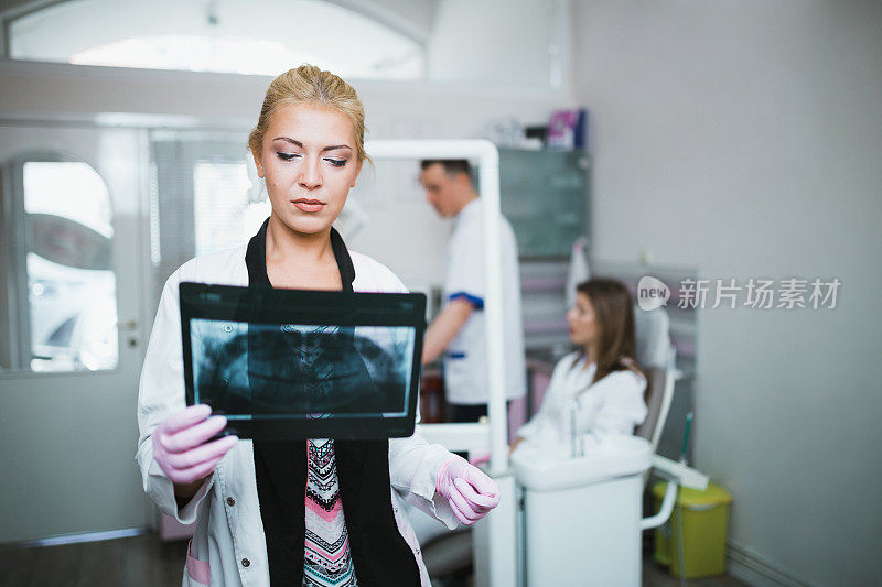 年轻的女牙医在看x光图像