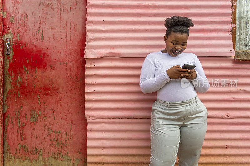 非洲小镇上的一名年轻女子正在使用手机