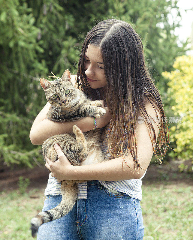 年轻女子抱着她友好的猫