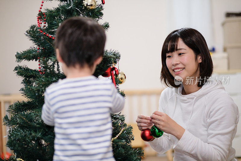 妈妈和孩子在家里装饰圣诞树