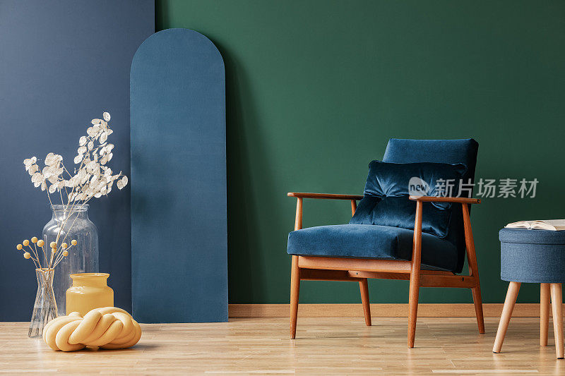复古的深蓝色扶手椅在优雅，客厅内部与空白的绿色和蓝色墙壁上的拷贝空间
