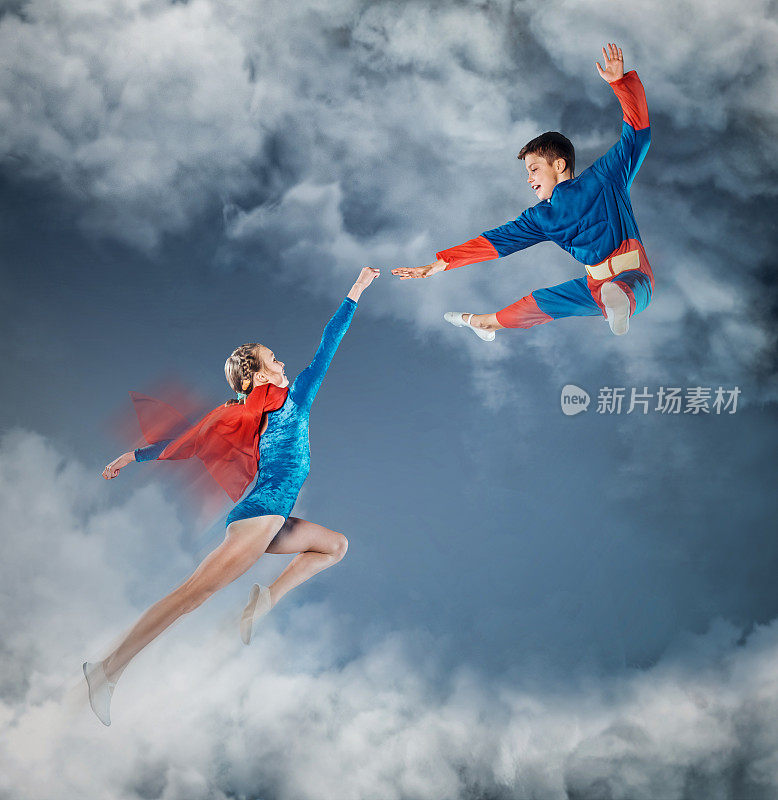 穿着超人衣服的有趣孩子在天空中飞翔。