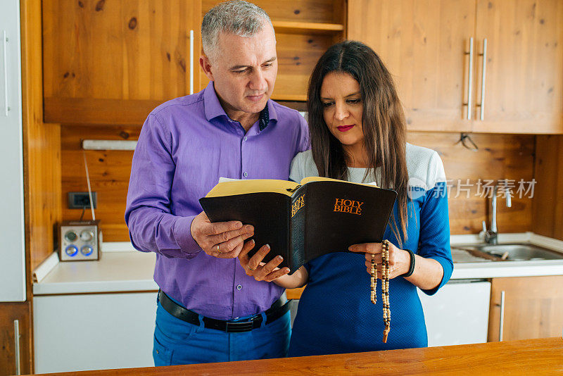 一对夫妇在房子里读上帝的话