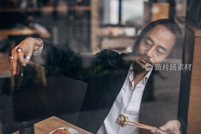 一名男子在餐厅吃寿司时自拍