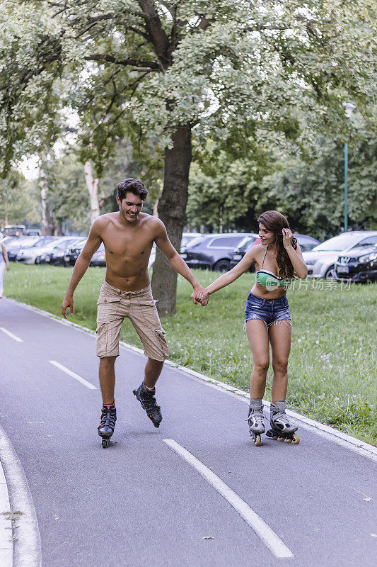 一对年轻夫妇在公园里滑旱冰鞋