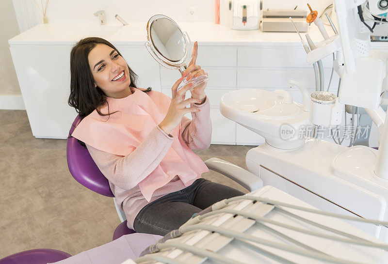 女病人在治疗后照镜子检查牙齿