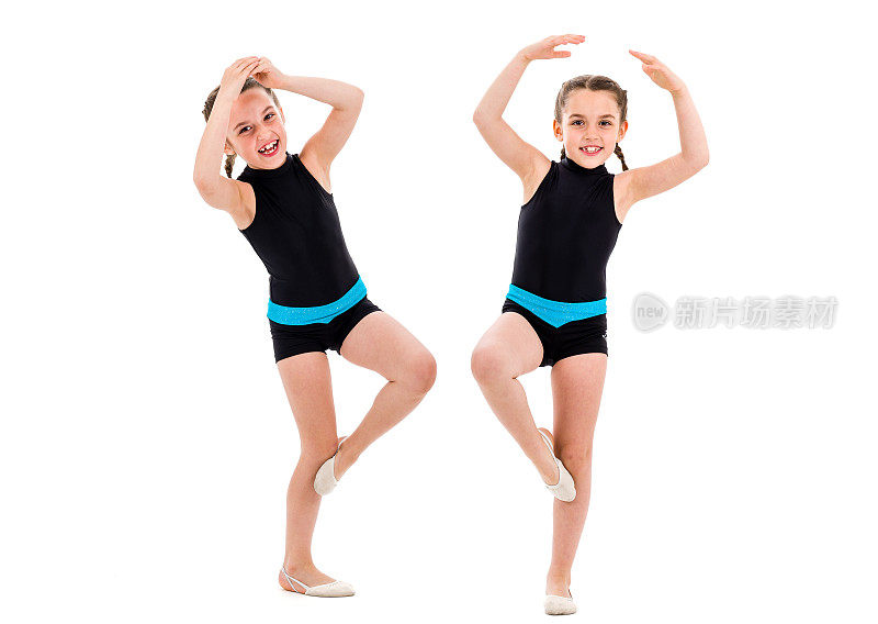 双胞胎女孩在白色背景下练习艺术体操。