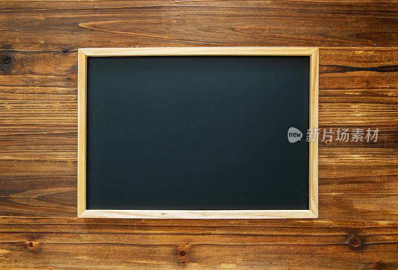 木墙背景上的空白黑板
