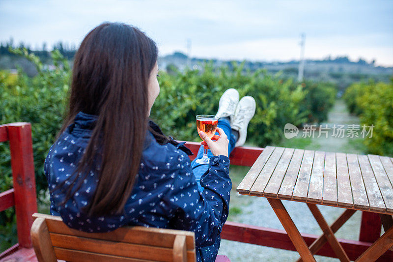 年轻女子在阳台上放松与葡萄酒库存照片