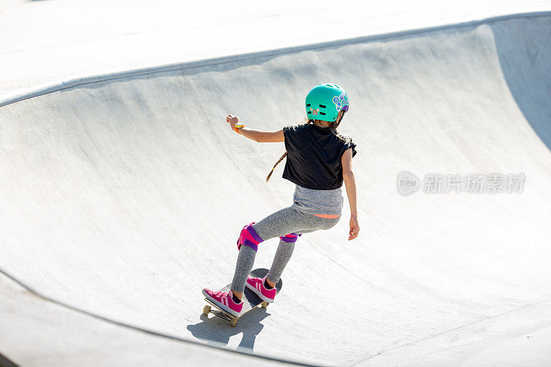 年轻女孩Cruisin溜冰公园在一个阳光明媚的日子-股票照片