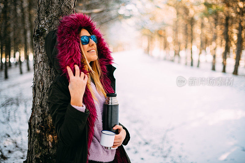 在雪域森林里喝咖啡的可爱女人