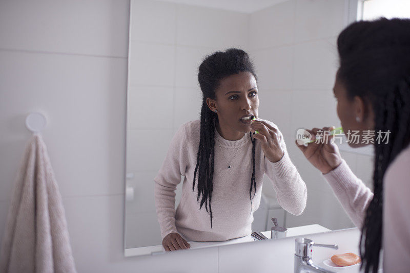 爱护牙齿健康的妇女，用牙刷清洁牙齿。