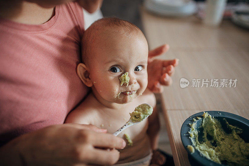 一位面目全非的母亲在给一个淘气的小男孩喂奶