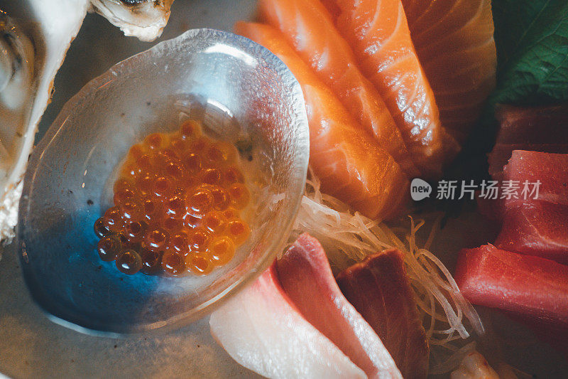 三文鱼籽配鲜鱼生鱼片，色彩斑斓，美味可口。日本料理生鱼片套装