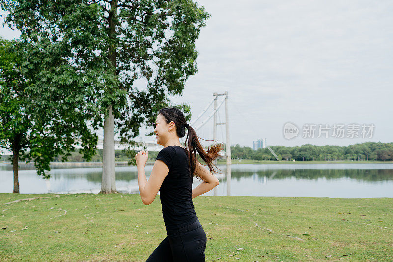 精力充沛的亚洲华人女子早上在公园跑步