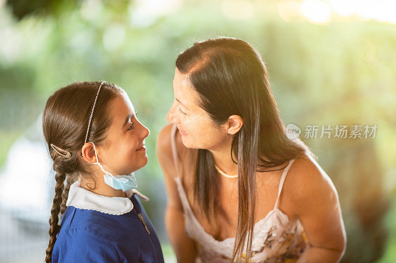 回到学校。教育的概念。准备去学校。新型冠状病毒肺炎母亲和女儿在上学的第一天。妈妈问候她的女儿