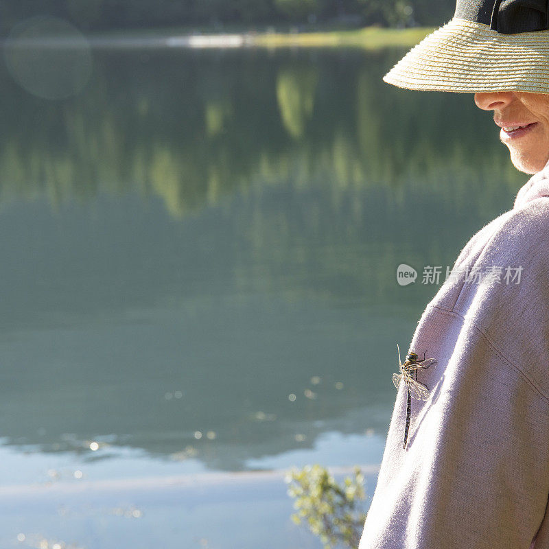 成熟的女人早晨在湖边放松