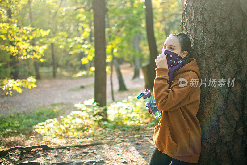 十几岁的女孩在运动或跑步后戴着头巾在公园休息