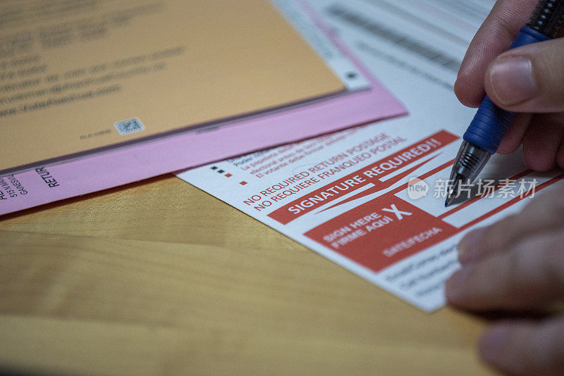 缺席选票表格与男子的手使用钢笔签名作为手指保持形式的地方