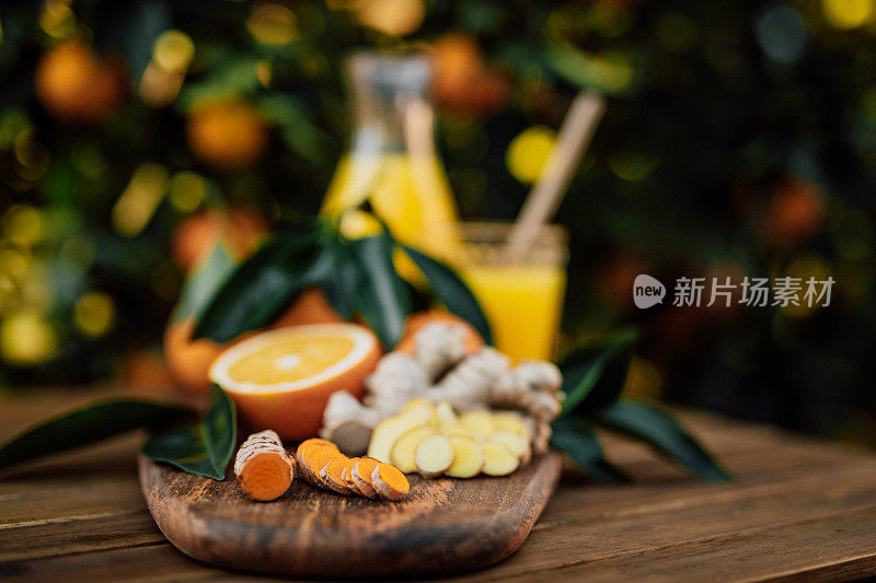 切片姜黄和生姜根和新鲜榨的橙汁从自己的花园未经处理的生物橙子