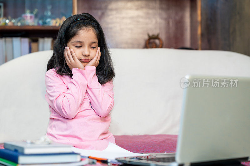 小女孩在家用笔记本电脑在线上课