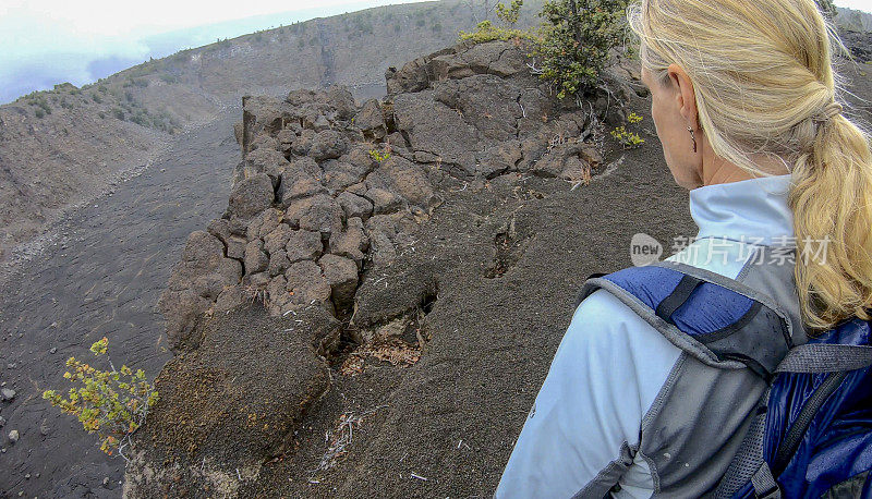 女人沿着火山边缘徒步旅行