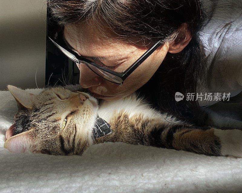 一个女人和一只猫在床上享受阳光