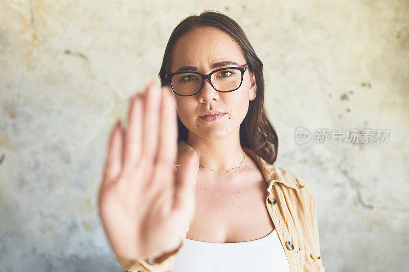 一个靠墙站着的女人举起手的肖像