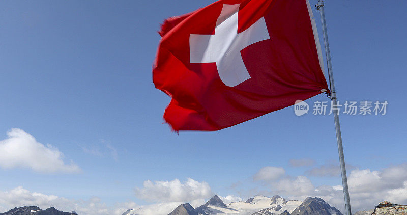 瑞士国旗在多岩石的山顶上迎风飘扬