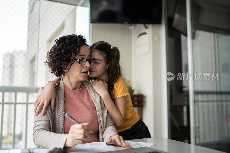 当他在家里工作的时候，女孩和妈妈聊天