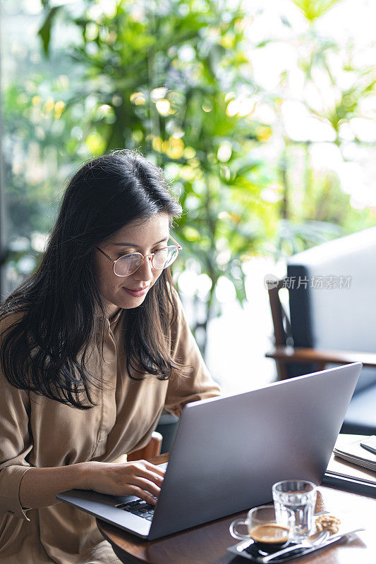 亚洲女大学生在咖啡馆用笔记本电脑远程学习