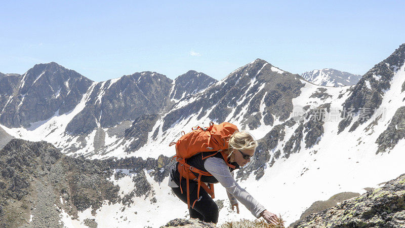 女登山运动员爬上阳光山岭
