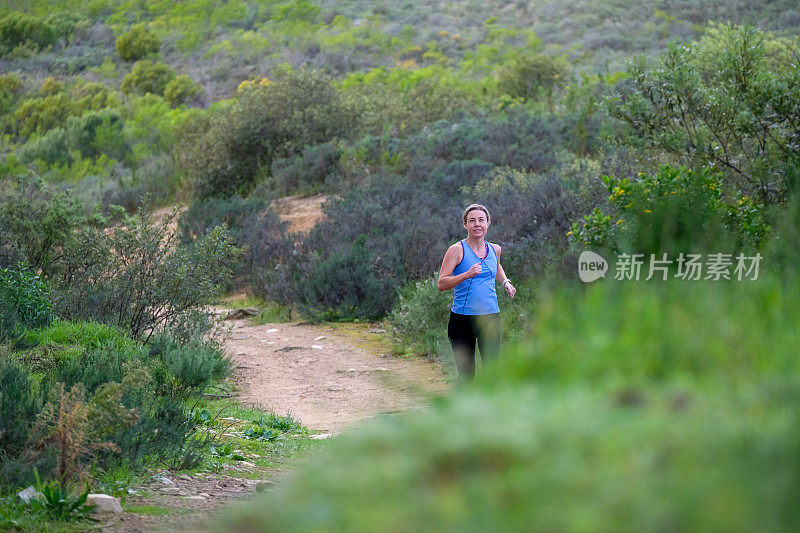 一个女人在山间小道上独自慢跑