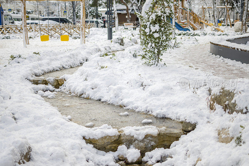 美丽的冬季公园，结冰的水覆盖着雪